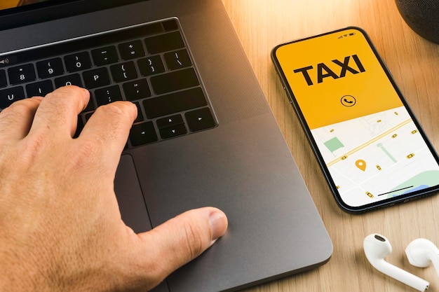 App Taxi Service sullo schermo dello smartphone sul tavolo di legno. Ambiente d'ufficio. Fornitore di servizi di mobilità in tutto il mondo.