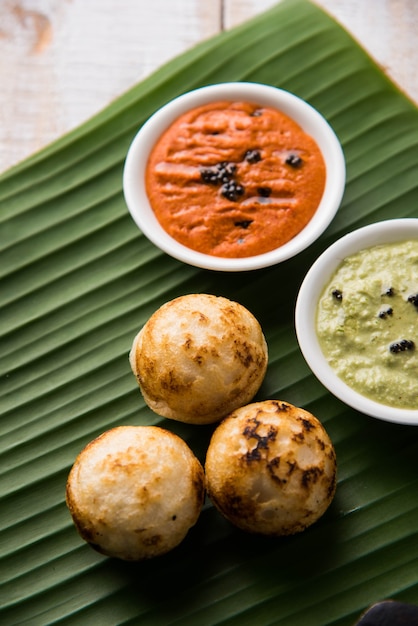 Appam o Mixed dal o Rava Appe serviti su uno sfondo lunatico con chutney verde e rosso. Una popolare ricetta per la colazione dell'India meridionale a forma di palla. Messa a fuoco selettiva