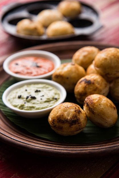 Appam o Mixed dal o Rava Appe serviti su uno sfondo lunatico con chutney verde e rosso. Una popolare ricetta per la colazione dell'India meridionale a forma di palla. Messa a fuoco selettiva