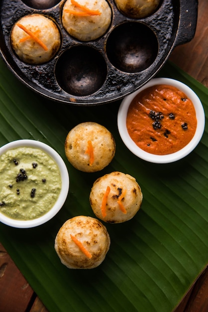 Appam o Mixed dal o Rava Appe serviti su uno sfondo lunatico con chutney verde e rosso. Una popolare ricetta per la colazione dell'India meridionale a forma di palla. Messa a fuoco selettiva