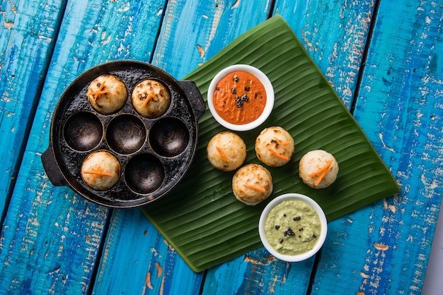 Appam o Mixed dal o Rava Appe serviti su uno sfondo lunatico con chutney verde e rosso. Una popolare ricetta per la colazione dell'India meridionale a forma di palla. Messa a fuoco selettiva