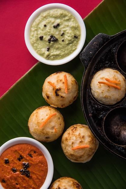 Appam o Mixed dal o Rava Appe serviti su uno sfondo lunatico con chutney verde e rosso. Una popolare ricetta per la colazione dell'India meridionale a forma di palla. Messa a fuoco selettiva