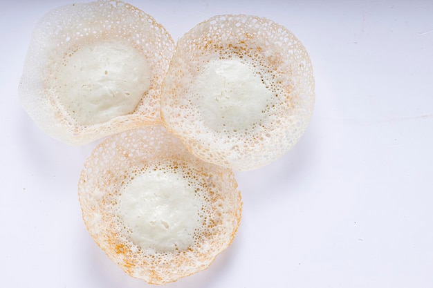 Appam o velliappam o kallappam o paalappam, gustoso e delizioso articolo per la colazione nell'india meridionale o nell'area del malabar, preparato con riso crudo e una buona combinazione per curry veg e non veg, posizionato su un bianco