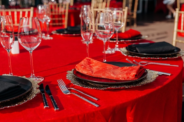 Apparecchio per la tavola degli ospiti per banchetti in stile nero, rosso e oro Disposizione per la cena elegante e di lusso
