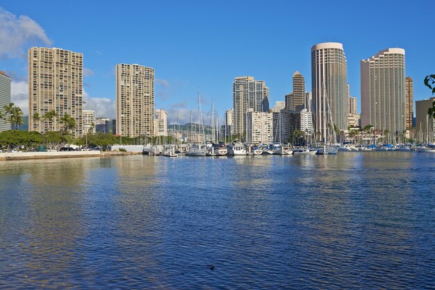 Appartamenti o quartieri degli affari accanto a un porto in una giornata di sole con un cielo azzurro nuvoloso Una popolare località turistica per le vacanze estive alle Hawaii Resort di lusso sull'oceano negli Stati Uniti su un mare tropicale