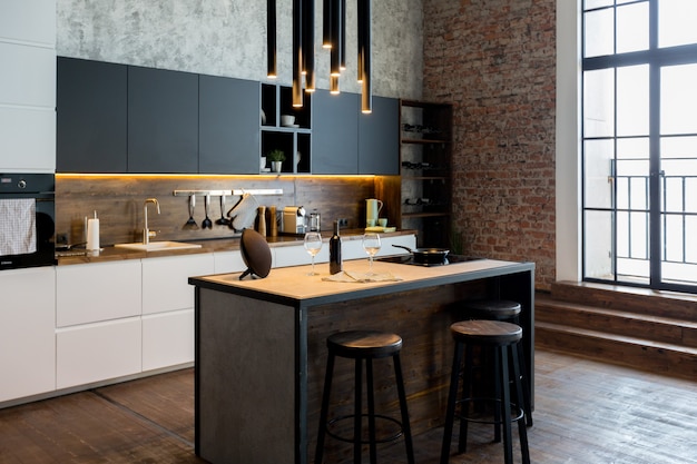 Appartamento di lusso in stile loft dai colori scuri. Elegante e moderna zona cucina con isola