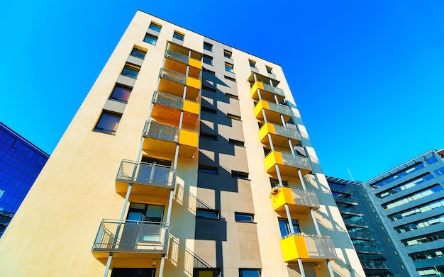 Appartamento in edificio residenziale esterno. Struttura abitativa in casa blu moderna d'Europa. Affitto casa nel quartiere della città in estate. Architettura alta parete e vetro per investimenti immobiliari aziendali.