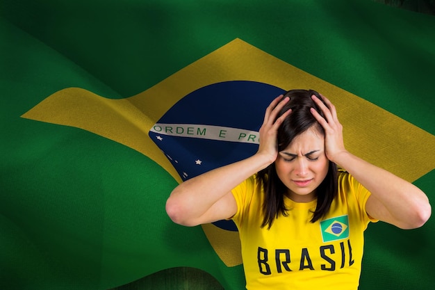 Appassionato di calcio sconvolto in maglietta brasiliana contro la bandiera nazionale brasiliana generata digitalmente