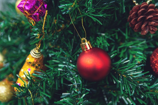 Appendere le palle rosse sulla ghirlanda dell&#39;albero di Natale rami di pino e ornamenti.