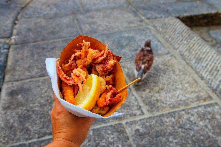 Appetito tipico italiano Fritto misto di pesce mix di frutti di mare fritti a mano femminile Snack sano a Genova Cinque Terre e Portofino