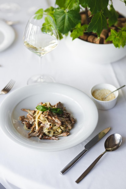 Appetitosa pasta italiana con funghi su sfondo chiaro.