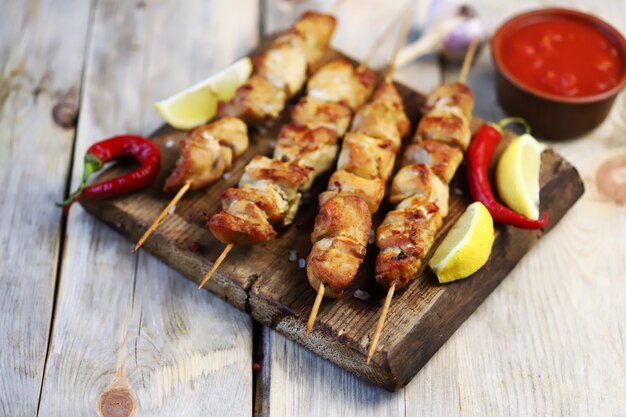 Appetitosi spiedini di pollo su bastoncini di legno. Stile rustico.