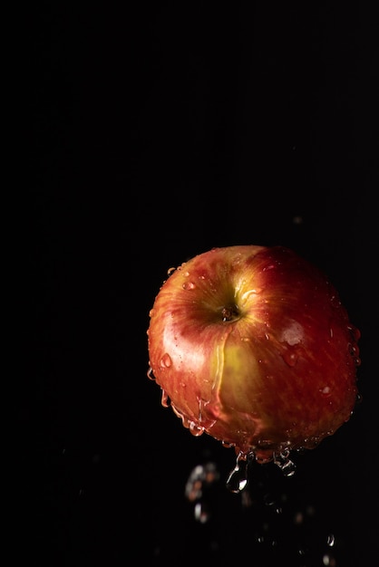 Apple con bella spruzzata di acqua con sfondo nero e messa a fuoco selettiva.