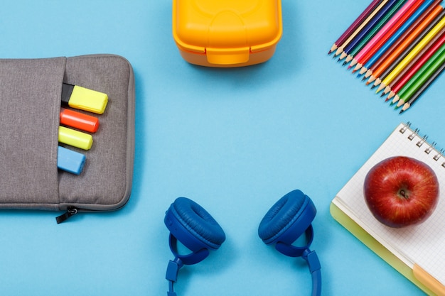 Apple su quaderno, matite, lunch box, cuffie, borsa-astuccio con pennarelli e pennarelli