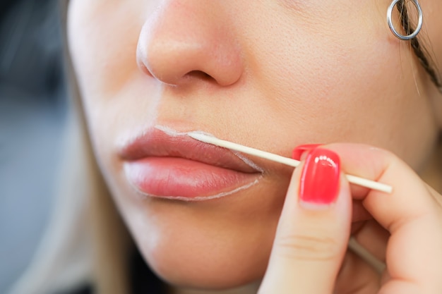 Applicare il contorno sulle labbra con una matita bianca prima della procedura di trucco permanente delle labbra