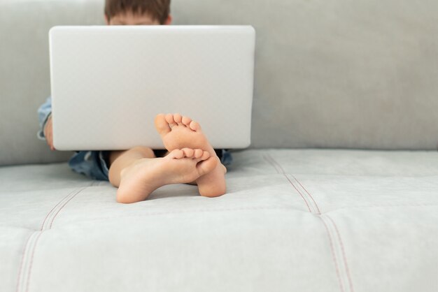 Apprendimento a distanza durante l'isolamento durante la quarantena nel coronovirus. Ragazzo e laptop a casa.