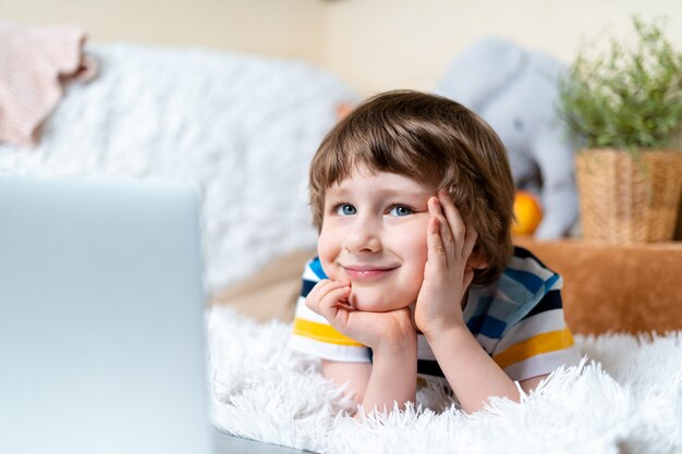 Apprendimento a distanza educazione online sorriso caucasico ragazzo che studia a casa con tablet laptop