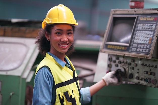 Apprendista femminile in una fabbrica di lavorazione dei metalli, Ritratto di un'operaia tecnica dell'industria femminile che lavora o una donna ingegnere che lavora in un'azienda di fabbrica di produzione industriale.