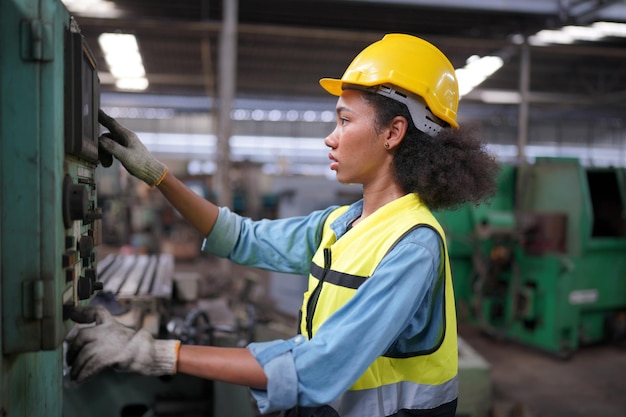 Apprendista femminile in una fabbrica di lavorazione dei metalli, Ritratto di un'operaia tecnica dell'industria femminile che lavora o una donna ingegnere che lavora in un'azienda di fabbrica di produzione industriale.