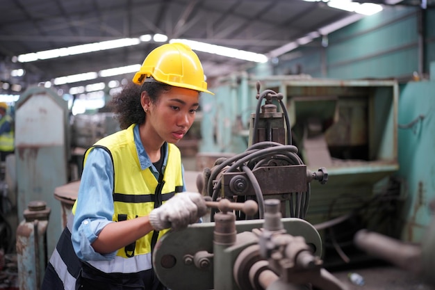 Apprendista femminile in una fabbrica di lavorazione dei metalli, Ritratto di un'operaia tecnica dell'industria femminile che lavora o una donna ingegnere che lavora in un'azienda di fabbrica di produzione industriale.