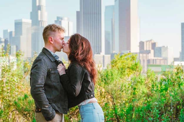 Appuntamento romantico di giovani uomini e donne su una panchina con vista sui grattacieli del centro di Los Angeles