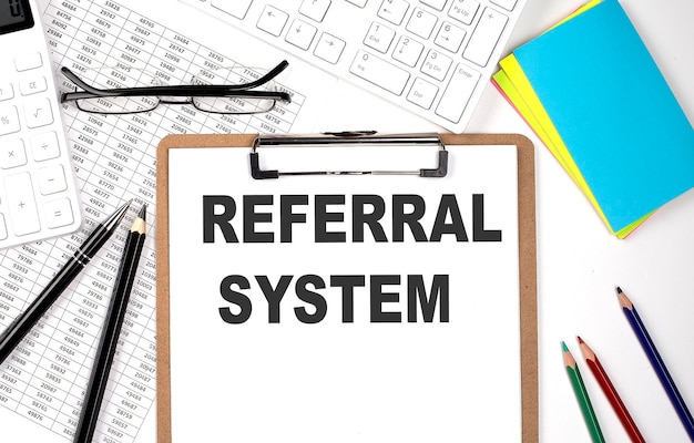 Appunti con testo REFERRAL SYSTEM e tastiera e grafico su sfondo bianco