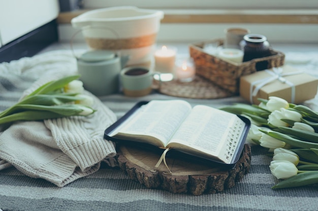 Apri la Bibbia su un supporto in legno con fiori in un interno domestico