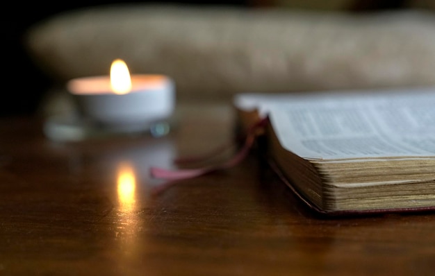 Aprire la Bibbia con una candela accesa sul tavolo