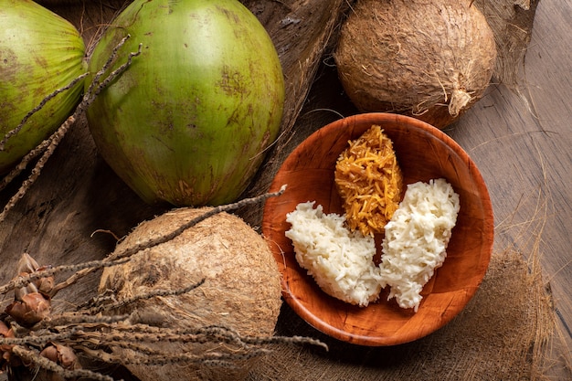 Aprire noci di cocco verdi e noci di cocco mature con cocada dolce sul tavolo