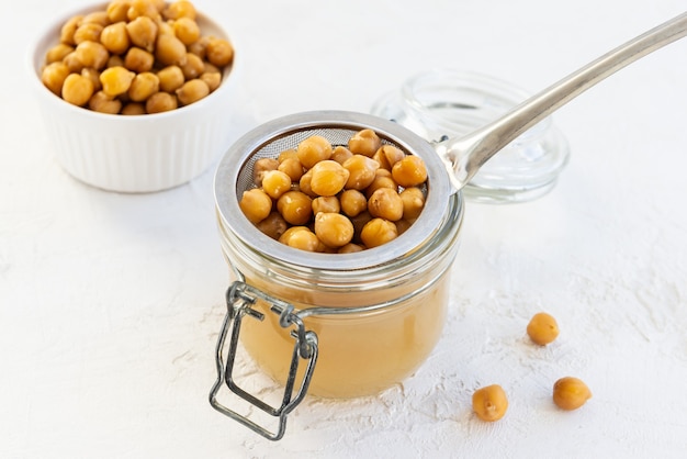 Aquafaba con ceci lessati in un barattolo di vetro