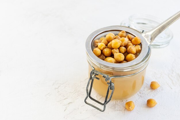 Aquafaba con ceci lessati in un barattolo di vetro