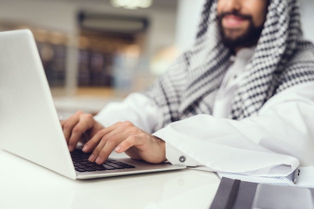 Arabian Man in Scarf Using Laptop in Cafe