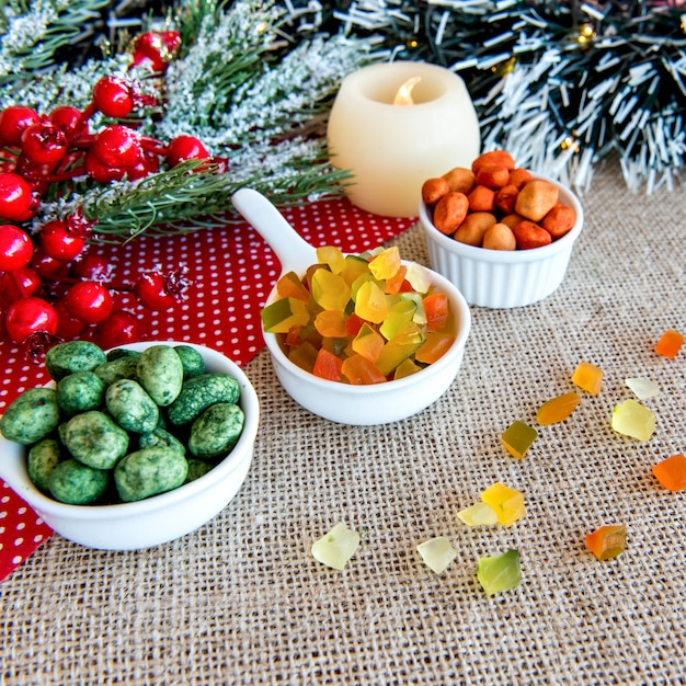 Arachidi colorate e frutta candita colorata su una tavola di Natale