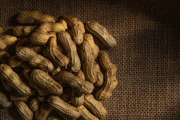 Arachidi organiche in guscio isolate su sfondo sacco Mucchio di arachidi closeup