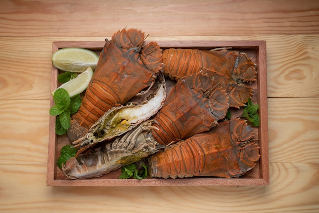 Aragosta a testa piatta su fondo di legno pronto da mangiare Piatto di frutti di mare