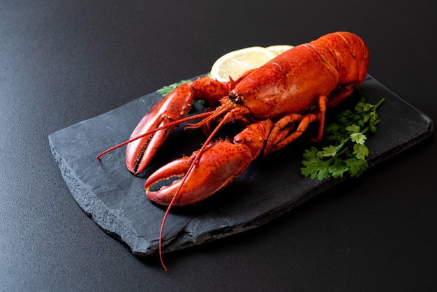 aragosta con verdure e limone su lastra di ardesia nera