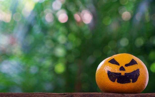 Arancia fresca con zucche di Halloween dipinta sul viso