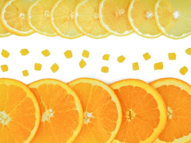 Arancia fresca, fetta di limone e piccoli pezzi su sfondo bianco.