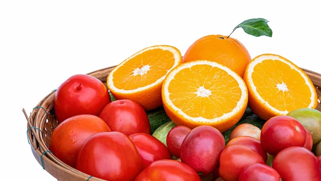 Arancia mezza matura Posizionare un cesto di bambù di frutta e verdura ricca di vitamina C come arance mature cetrioli e pomodori su uno sfondo bianco