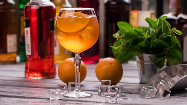 Aranciata in bicchiere di vino. Cubetti di ghiaccio e arance. Ricetta dell'Aperol spritz. Il cocktail più gustoso del nostro bar.