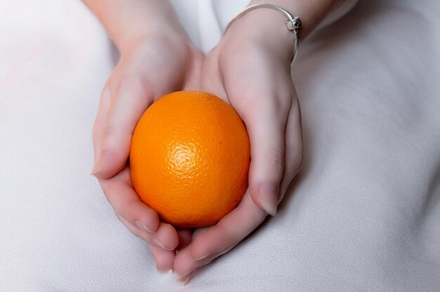 Arancio nelle sue mani Ragazza.
