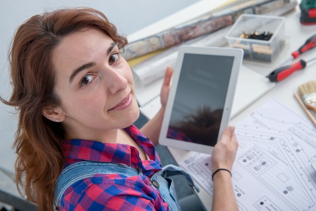 Architetto arredatore della giovane donna che per mezzo della compressa digitale