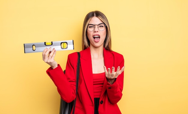 Architetto donna che sembra disperata, frustrata e stressata e mantiene un equilibrio di livello