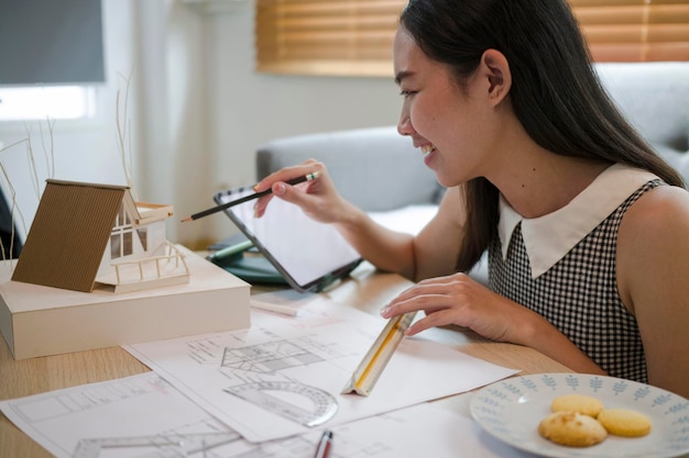 Architetto femminile che lavora con il tablet del computer a casa