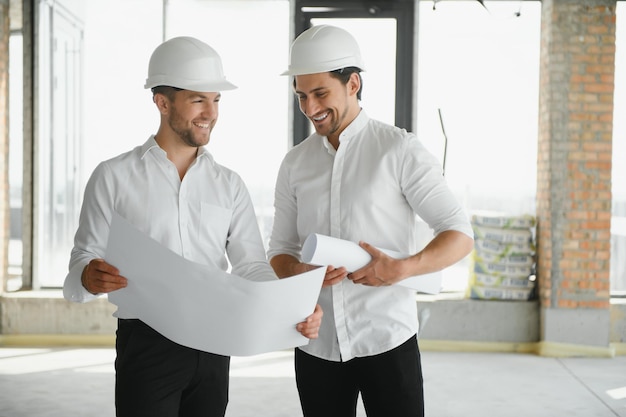 Architetto maschio che dà istruzioni al suo caposquadra al cantiere