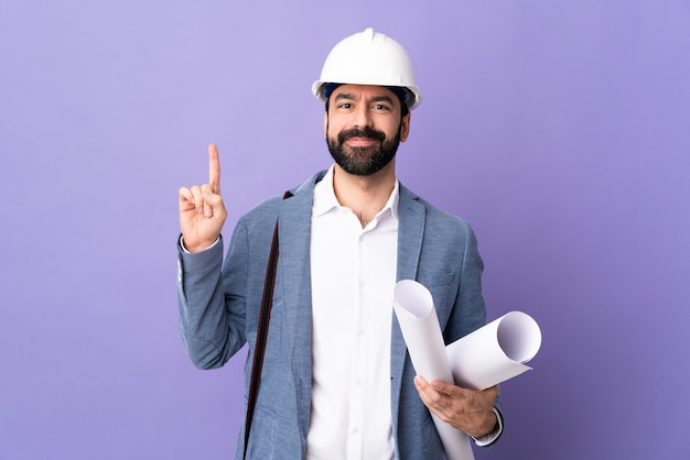 Architetto maschio in posa con il casco e rivolto verso l'alto