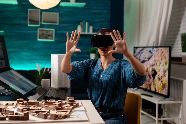 Architetto professionista che utilizza occhiali vr per la creazione di ologrammi visivi su tecnologia interattiva 3d sul posto di lavoro in ufficio. Donna dell'ingegnere edile che progetta simulazione digitale creativa