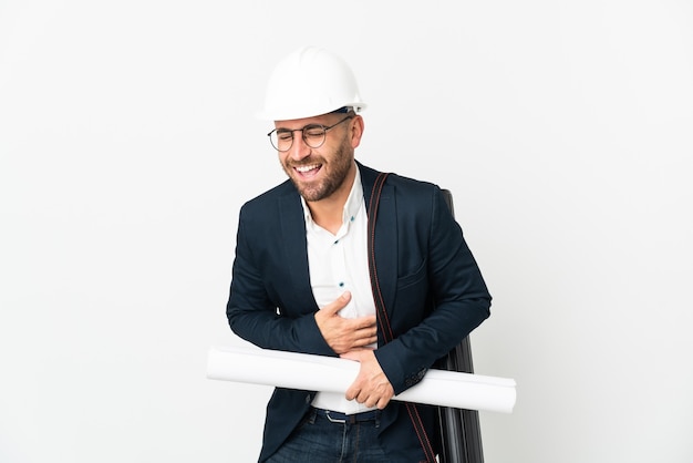 Architetto uomo con casco e tenendo progetti isolati su sfondo bianco sorridendo molto