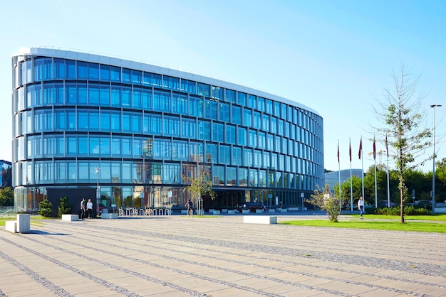 Architettura commerciale moderna del grattacielo del forum di vetro e acciaio che riflette il cielo blu