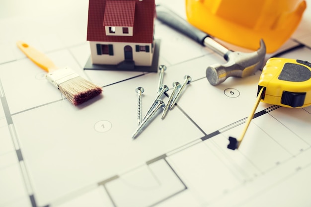 architettura, costruzione, immobiliare e concetto di casa - primo piano di modello di casa vivente su progetto con strumenti di riparazione